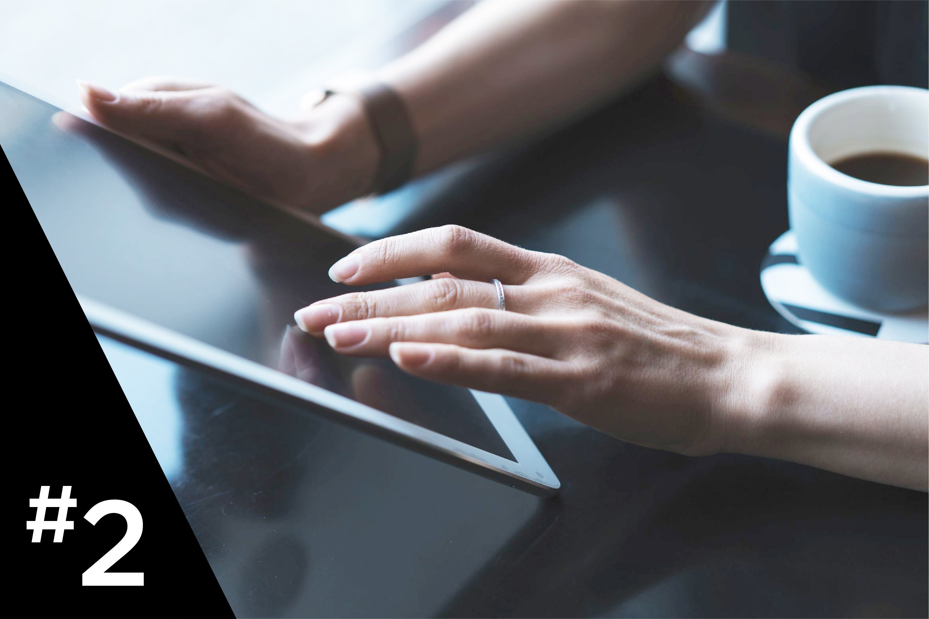 Woman working on a tablet with a cup of coffee
